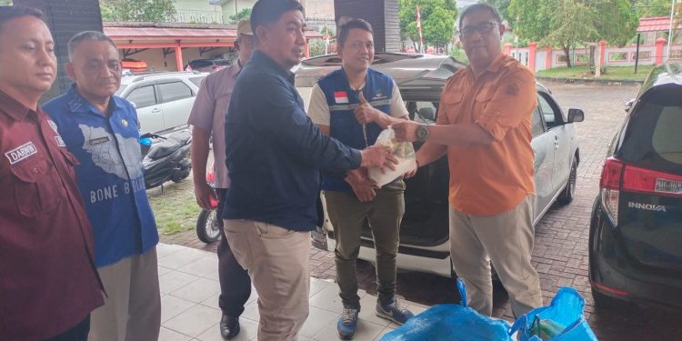Pj Sekda Bone Bolango, Aznan Nadjamudin saat menyerahkan bantuan paket sembako untuk masyarakat Kecamatan Bone yang terdampak banjir