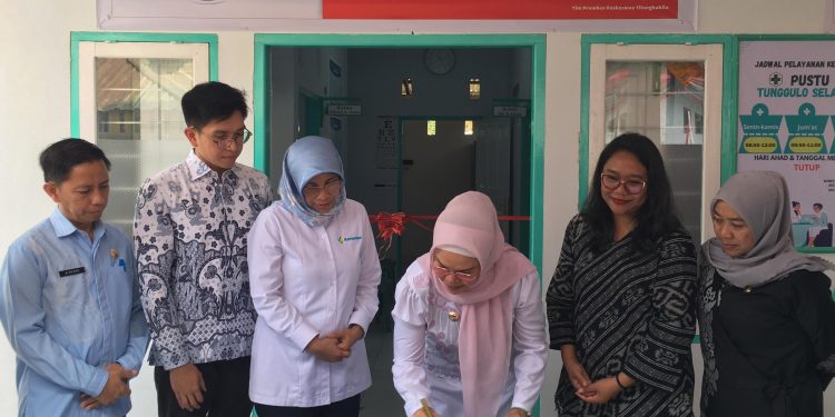Bupati Merlan S. Uloli didampingi Sekretaris Direktorat Jenderal Kesehatan Masyarakat. dr. Niken Wastu Palupi saat menandatangani prasasti peresmian Integrasi Layanan Primer di Puskesmas Pembantu Desa Tunggulo Selatan, Kamis (19/9/2024). (F.Indra/Diskominfo)