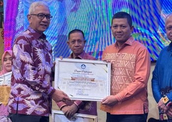 Penjabat Gubernur Gorontalo, Rudy Salahuddin saat menyerahkan Piagam Penghargaan kebijakan Merdeka Belajar kepada Kepala Dinas Pendidikan dan Kebudayaan Kabupaten Bone Bolango, Adrien Andjar di Hotel Aston Kota Gorontalo, Minggu (20/10/2024). (Foto Dok Dinas Pendidikan dan Kebudayaan)