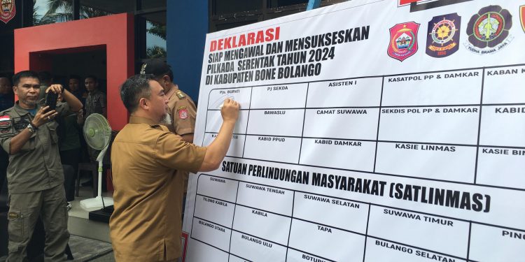 Pjs Bupati Bone Bolango, Budiyanto Sidiki saat menandatangani Deklarasi Siap Mengawal dan Mensukseskan Pilkada Serentak 2024 usai pelaksanaan Apel Siaga Satlinmas Dalam Menghadapi Pilkada Serentak Tahun 2024 di Kabupaten Bone Bolango yang dilaksanakan di Halaman Dinas Satpol PP dan Pemadam Kebakaran, Selasa (12/11/2024). (F. Indra/Diskominfo)