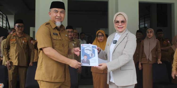 Pjs Bupati Bone Bolango 2024, Budiyanto Sidiki saat menyerahkan nota kinerja kepada Bupati Bone Bolango, Merlan S. Uloli pada pelaksaan apel kerja di lingkungan Pemerintah Kabupaten Bone Bolango, Senin (25/11/2024). (Foto Yudi/Prokopim)