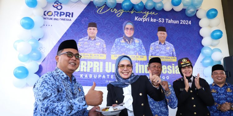 Bupati Merlan S. Uloli saat membagikan potongan tumpeng kepada Forkopimda pada Peringatan HUT Korpri ke-53 tingkat Kabupaten Bone Bolango yang dilaksanakan di Lapangan Alun-Alun, Jumat (29/11/2024). (Foto Adit/Prokopim)