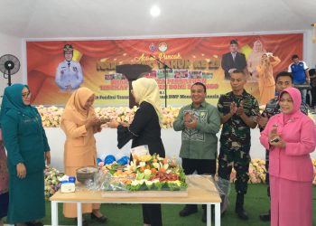 Bupati Merlan S. Uloli saat membagikan potongan tumpeng buah kepada tamu undangan pada perayaan Hari Ulang Tahun (HUT) ke-25 Dharma Wanita Persatuan (DWP) yang dilaksanakan di Bandayo Li Mbui, Kecamatan Kabila, Jumat (13/12/2024). (Foto Indra/Diskominfo)