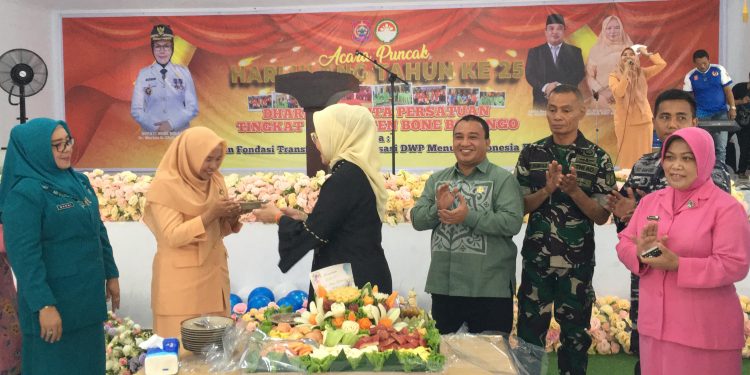 Bupati Merlan S. Uloli saat membagikan potongan tumpeng buah kepada tamu undangan pada perayaan Hari Ulang Tahun (HUT) ke-25 Dharma Wanita Persatuan (DWP) yang dilaksanakan di Bandayo Li Mbui, Kecamatan Kabila, Jumat (13/12/2024). (Foto Indra/Diskominfo)