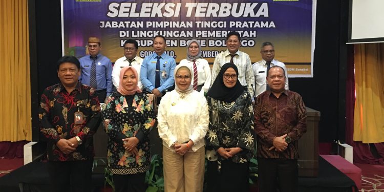 Bupati Merlan S. Uloli didampingi panitia seleksi dan tim assesor saat foto bersama dengan enam pejabat yang mengikuti Seleksi Terbuka Jabatan Pimpinan Tinggi Pratama Sekretaris Daerah di Lingkungan Pemerintah Kabupaten Bone Bolango di Grand Q Hotel Kota Gorontalo, Kamis (5/12/2024). (Foto Indra/Diskominfo)