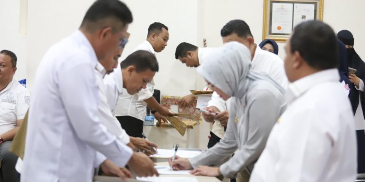 Para asisten, staf ahli, pimpinan OPD hingga camat saat melakukan penandatanganan perjanjian kinerja tahun 2025 di hadapan Bupati Bone Bolango, Merlan S. Uloli di Ruang Rapat Bupati, Rabu (22/1/2025). (Foto Onal/Prokopim)