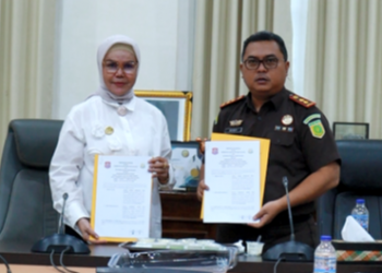 Bupati Bone Bolango, Merlan S. Uloli dan Kepala Kejaksaan Negeri Bone Bolango, Deddy Herliyantho saat foto bersama usai melakukan penandatangan kesepakatan bersama penyelesaian masalah hukum di bidang Perdata dan Tata Usaha Negara yang dilaksanakan di Ruang Rapat Bupati, Senin (20/1/2025). (Foto Fauzi/Diskominfo)