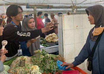 Mahasiswa magang Diskominfo Bone Bolango saat melakukan pemantauan dan mewawancarai pada pedagang terkait harga kebutuhan pokok di Pasar Mingguan, Kecamatan Suwawa, Rabu (26/2/2025). (Foto Fahri/Magang Diskominfo)