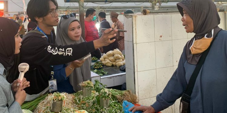 Mahasiswa magang Diskominfo Bone Bolango saat melakukan pemantauan dan mewawancarai pada pedagang terkait harga kebutuhan pokok di Pasar Mingguan, Kecamatan Suwawa, Rabu (26/2/2025). (Foto Fahri/Magang Diskominfo)