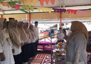 Ketua Tim Pembina Posyandu Bone Bolango, Ruwaida Mile saat mengukuhkan Tim Pembina Posyandu Kecamatan dan Desa se-Kecamatan Kabila Bone di Lorong 5 Pantai Botutonuo, Minggu (27/7/2025). (Foto Indra/Diskominfo)