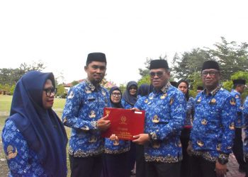 Sekda Iwan Mustapa saat menyerahkan penghargaan Satya Lencana kepada ASN saat memimpin Apel Korpri di Lapangan Alun-Alun Bone Bolango, Rabu (17/9/2025). (F. AKP/Diskominfo)