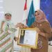 Sekretaris Utama BKN, Imas Sukmariah saat menyerahkan Penghargaan Terbaik I atas Pencapaian Progres Nilai Kualitas Data ASN kepada Kepala BKPSDM Bone Bolango, Friske Aryanti Usman, Senin (20/10/2025). (F.Istimewa)