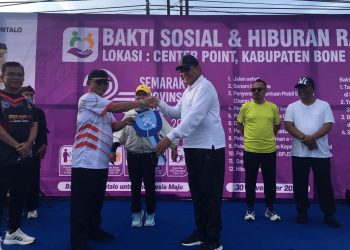 Bupati Ismet Mile saat menerima secara simbolis bantuan mobil pengangkut sampah yang diserahkan oleh Gubernur Gusnar Ismail dan Wagub Idah Syahidah Rusli Habibie pada Semarak HUT Provinsi Gorontalo ke-25 di Bone Bolango, Minggu (30/11/2025). (F.Indra/Diskominfo)