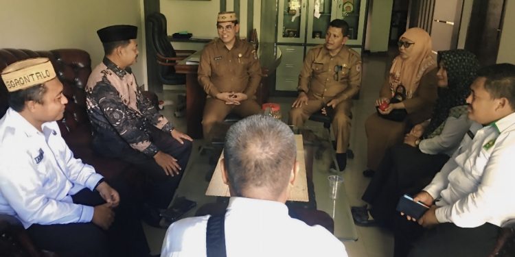 Sekretaris Daerah Bone Bolango, Iwan Mustapa menerima Audiensi Kepala Kantor Kementerian Haji dan Umrah Bone Bolango, Abdulrahman Yusuf bersama jajaran di Ruang Kerja Sekda, Selasa (2/12/2025). (F.Indra/Diskominfo)