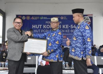 Bupati Ismet Mile saat menerima piagam penghargaan dari Kepala BPJS Ketenagakerjaan Gorontalo, Sanco Simanullang atas komitmennya melindungi seluruh Pengurus Koperasi Desa/Kelurahan Merah Putih (KDKMP) melalui program jaminan sosial ketenagakerjaan yang dibiayai langsung oleh APBD, Senin (1/12/2025). (F.Indra/Diskominfo)