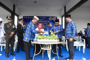 Bupati Ismet Mile didampingi Wabup Risman Tolingguhu, Sekda Iwan Mustapa, Ketua T.P PKK Ruwaida Ismet Mile dan jajaran Forkopimda saat melakukan pemotongan tumpeng pada menggelar Peringatan HUT Korpri ke-54, HUT PGRI, dan Hari Guru Nasional ke-80 di Lapangan Alun-Alun Bone Bolango, Senin (1/12/2025). (F.AKP/Diskominfo)