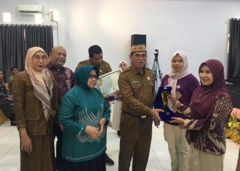 Sekda Iwan Mustapa didampingi Kepala Pusat Analisis Perpustakaan dan Pengembangan Budaya Baca, Nurhadi Saputra serta Bunda Literasi Bone Bolango, Ruwaida Ismet Mile saat menyerahkan bonus dan penghargaan Apresiasi Lomba Perpustakaan Desa/Kelurahan tingkat Kabupaten Bone Bolango di BPU Kabila, Selasa (2/12/2025). (F.Indra/Diskominfo)