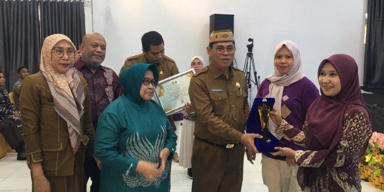 Sekda Iwan Mustapa didampingi Kepala Pusat Analisis Perpustakaan dan Pengembangan Budaya Baca, Nurhadi Saputra serta Bunda Literasi Bone Bolango, Ruwaida Ismet Mile saat menyerahkan bonus dan penghargaan Apresiasi Lomba Perpustakaan Desa/Kelurahan tingkat Kabupaten Bone Bolango di BPU Kabila, Selasa (2/12/2025). (F.Indra/Diskominfo)
