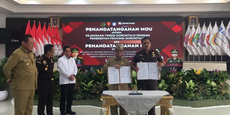 Bupati Ismet Mile didampingi Kepala Kejaksaan Negeri Bone Bolango, Feddy Hantyo Nugroho saat menghadiri Penandatanganan Nota Kesepahaman (MoU) antara Kejaksaan Tinggi Gorontalo dan Pemerintah Provinsi Gorontalo, serta Penandatanganan Perjanjian Kerja Sama (PKS) antara Kejaksaan Negeri dengan Pemerintah Kabupaten/Kota se-Provinsi Gorontalo tentang Penerapan Pidana Kerja Sosial bagi Pelaku Tindak Pidana, yang berlangsung di Aula Rumah Jabatan Gubernur Gorontalo, Senin (22/12/2025). (F.Indra/Diskominfo)
