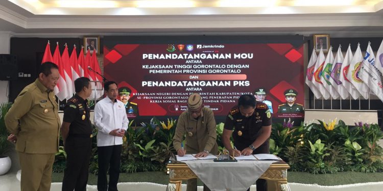 Kepala Kejaksaan Negeri Bone Bolango, Feddy Hantyo Nugroho, didampingi Bupati Ismet Mile saat menghadiri Penandatanganan Nota Kesepahaman (MoU) antara Kejaksaan Tinggi Gorontalo dan Pemerintah Provinsi Gorontalo, serta Perjanjian Kerja Sama (PKS) antara Kejaksaan Negeri dengan Pemerintah Kabupaten/Kota se-Provinsi Gorontalo tentang Penerapan Pidana Kerja Sosial bagi Pelaku Tindak Pidana, di Aula Rumah Jabatan Gubernur Gorontalo, Senin (22/12/2025). (F.Indra/Diskominfo)