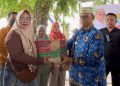 Bupati Bone Bolango, Ismet Mile, menyerahkan bantuan sarana usaha bagi 62 pelaku UMKM di wilayah Tilongkabila yang dipusatkan di Taman Kuliner Centerpoint, Senin (1/12/2025). (F.Sandi/Diskominfo)