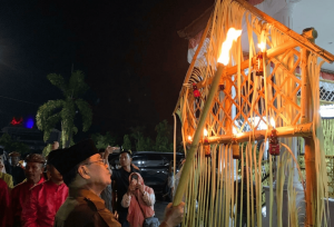 Sekda Iwan Mustapa saat menyalakan lampu botol pada perayaan Tumbilotohe di Kabupaten Bone Bolango, Senin (16/3/2026) malam. (F.Indra/Diskominfo)