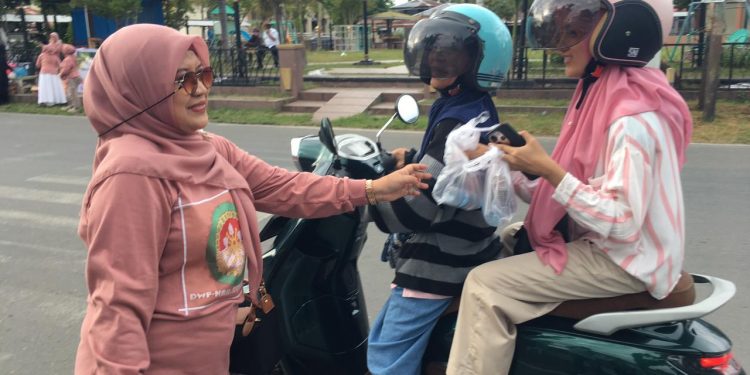 Ketua DWP Bone Bolango, dr.Nurliana Ibrahim saat membagikan takjil kepada masyarakat, Sabtu (!4/3/2026). (F.Indra/Diskominfo)