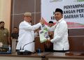 Bupati Ismet Mile saat menyerahkan LKPJ Tahun 2025 kepada Ketua DPRD, Faisal Yunus, Selasa (31/3/2026). (F. Rivan/Magang)
