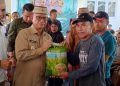 Bupati Bone Bolango, Ismet Mile, menyalurkan bantuan benih Padi Mekongga dan bantuan pangan di Halaman Dinas Ketahanan Pangan dan Pertanian Bone Bolango, Senin (6/4/2026). (F. Rivan/Magang)
