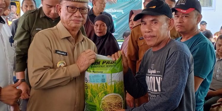Bupati Bone Bolango, Ismet Mile, menyalurkan bantuan benih Padi Mekongga dan bantuan pangan di Halaman Dinas Ketahanan Pangan dan Pertanian Bone Bolango, Senin (6/4/2026). (F. Rivan/Magang)