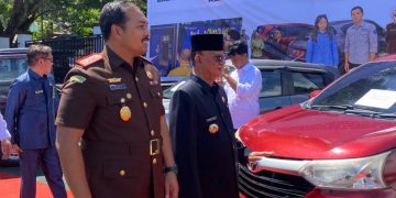 Bupati Ismet Mile didampingi Kajari Feddy Hantyo Nugroho pada penyerahan puluhan kendaraan dinas hasil permohonan bantuan hukum non litigasi dari Badan Keuangan dan Pendapatan Daerah (BKPD) kepada Kejaksaan Negeri Bone Bolango di halaman Kantor Kejaksaan Negeri Bone Bolango, Rabu (20/5/2026). (F.Magang/Diskominfo)