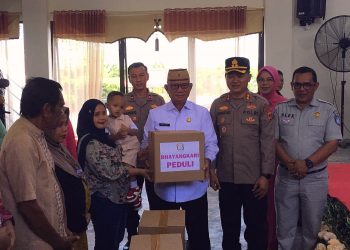 Bupati Ismet Mile saat menyerahkan paket bantuan kepada masyarakat. (F.Indra/Diskominfo)