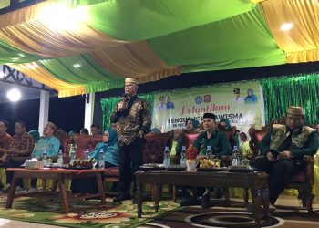 Bupati Ismet Mile didampingi Ketua T.P PKK Ruwaida Ismet Mile saat memberikan sambutan pada pelantikan pengurus dasawisma se-Kecamatan Suwawa Tengah, Rabu (10/6/2026) malam tadi. (F.Indra/Diskominfo)