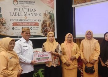 Sekda Iwan Mustapa didampingi Ketua DWP Bone Bolango, dr.Nurliana Ibrahim saat menyerahkan bantuan modal UMKM, Rabu (8/7/2026). (F.Munifa/Diskominfo)