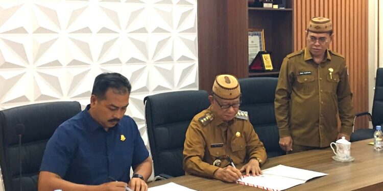 Bupati Bone Bolango, Ismet Mile didampingi Sekda Iwan Mustapa pada kegiatan Penandatanganan NPHD dan BAST tentang Perjanjian Hibah Tanah untuk Pembangunan Rumah Susun Kejari Bone Bolango yang digelar di Ruang Rapat Bupati, Selasa (28/7/2026). (F.Indra/Diskominfo)