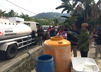 Bupati Bone Bolango, Ismet Mile, turun langsung memimpin penyaluran air bersih bagi warga terdampak di Desa Tamboo dan Desa Lonuo, Kecamatan Tilongkabila, Jumat (31/7/2026). (F.Indra/Diskominfo)
