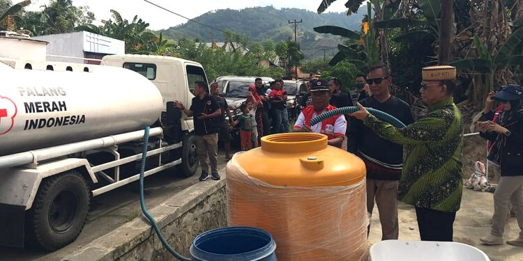 Bupati Bone Bolango, Ismet Mile, turun langsung memimpin penyaluran air bersih bagi warga terdampak di Desa Tamboo dan Desa Lonuo, Kecamatan Tilongkabila, Jumat (31/7/2026). (F.Indra/Diskominfo)