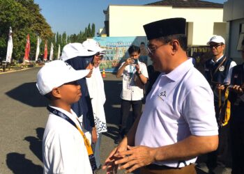 Sekda Iwan Mustapa saat menyematkan tanda peserta Masa Pengenalan Lingkungan Sekolah Nasional Terintegrasi di BPMP Provinsi Gorontalo, Senin (10/8/2026). (F.Indra/Diskominfo)