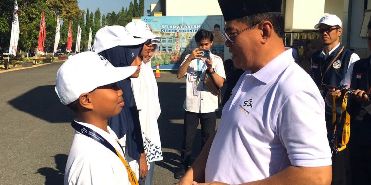 Sekda Iwan Mustapa saat menyematkan tanda peserta Masa Pengenalan Lingkungan Sekolah Nasional Terintegrasi di BPMP Provinsi Gorontalo, Senin (10/8/2026). (F.Indra/Diskominfo)