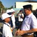 Sekda Iwan Mustapa saat menyematkan tanda peserta Masa Pengenalan Lingkungan Sekolah Nasional Terintegrasi di BPMP Provinsi Gorontalo, Senin (10/8/2026). (F.Indra/Diskominfo)