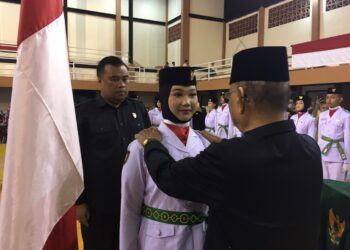 Bupati Ismet Mile saat mengukuhkan Pasukan Pengibar Bendera Pusaka (Paskibraka) Kabupaten Bone Bolango Tahun 2026 di Gedung Olahraga Indoor Oginawa Suwawa, Sabtu (15/8/2026) malam. (F.Indra/Diskominfo)